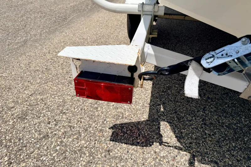 Slide: The Image of Trailer light and hitch of a 2004 Bombardier SEADOO Utopia 185 on asphalt. - 58