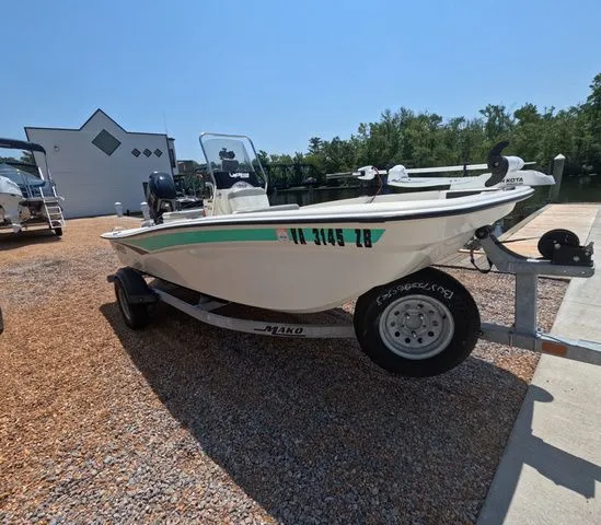 Slide: The Image of A 2023 Mako Pro Skiff 15 CC on a trailer near a body of water. - 4