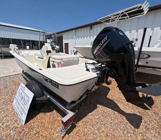 Slide: The Image of A 2023 Mako Pro Skiff 15 CC boat on a trailer in an outdoor setting. - 8