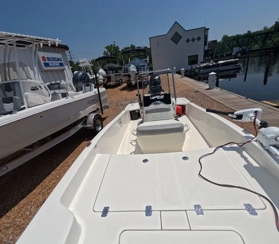 Slide: The Image of A 2023 Mako Pro Skiff 15 CC is docked beside other boats. - 13