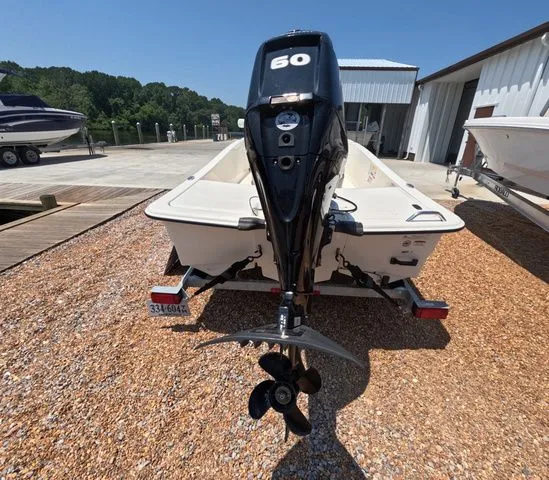 Slide: The Image of A 2023 Mako Pro Skiff 15 CC on a gravel lot. The outboard motor is visible. - 7