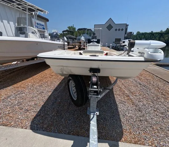 Slide: The Image of A 2023 Mako Pro Skiff 15 CC on a trailer beside a dock. - 3