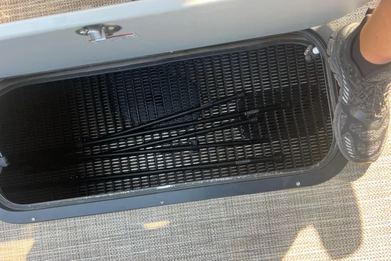 Slide: The Image of Open storage compartment in 2022 Viaggio Lago V-U 22 boat, showing black rods inside. - 36