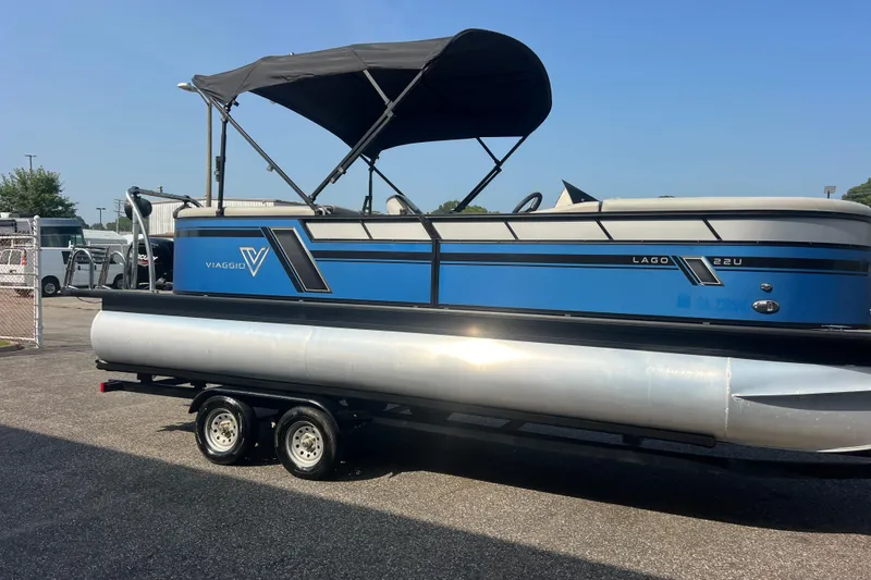 Slide: The Image of 2022 Viaggio Lago V-U 22 pontoon boat on trailer, blue and silver design. - 13