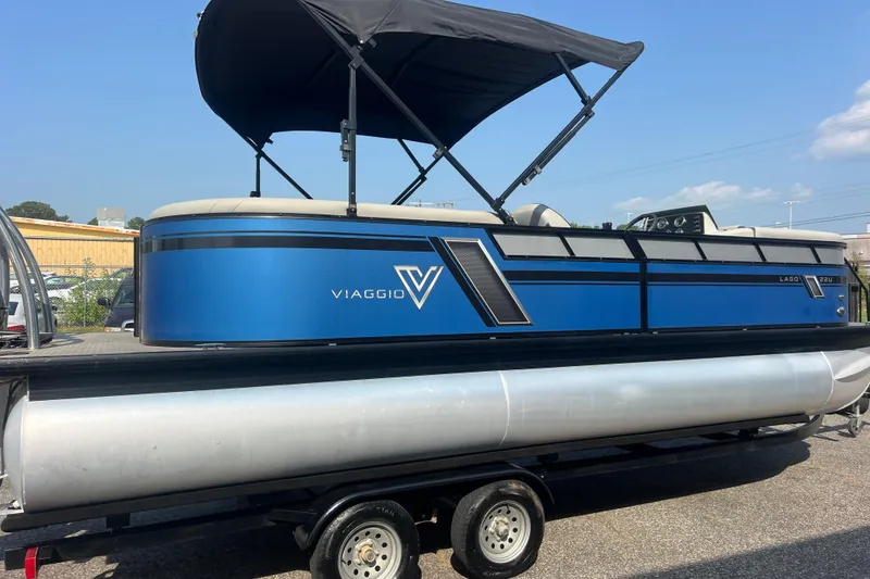 Slide: The Image of 2022 Viaggio Lago V-U 22 pontoon boat with blue exterior and black canopy on trailer. - 12