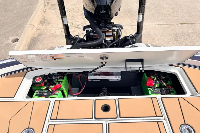 Slide: The Image of Open battery compartment of 2026 Ranger Z521R Ultra boat, showcasing green batteries and wiring. - 58