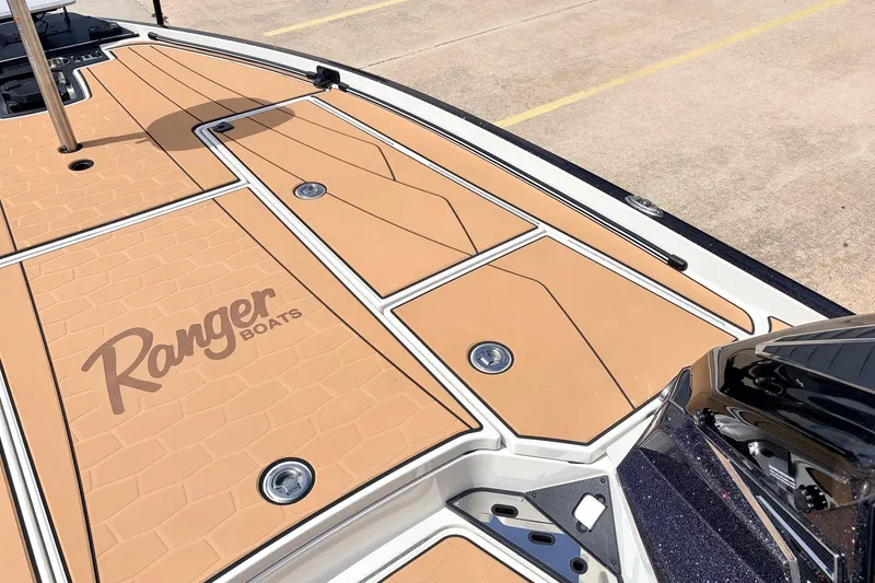 Slide: The Image of 2026 Ranger Z521R Ultra boat deck with tan panels and logo, parked on concrete. - 24
