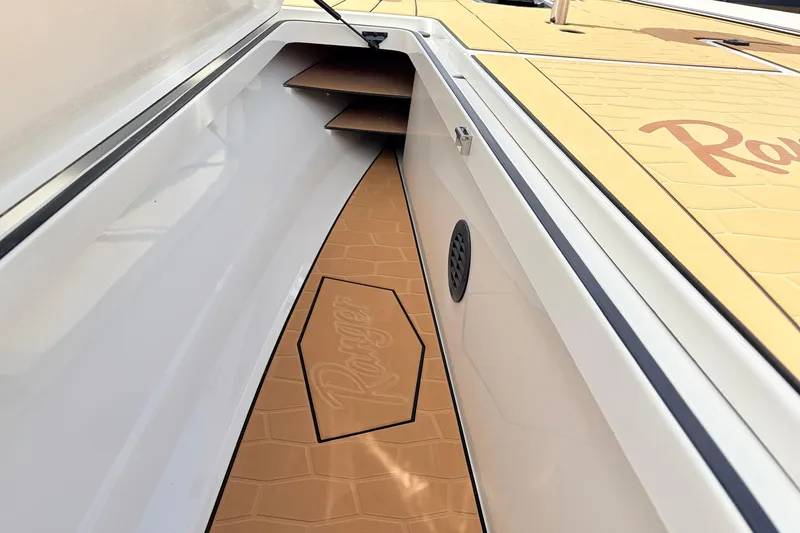 Slide: The Image of 2026 Ranger Z521R Ultra boat interior with tan flooring and storage compartments. - 20