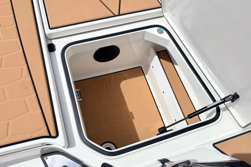 Slide: The Image of Storage compartment of 2026 Ranger Z521R Ultra boat, featuring tan interior and hydraulic lift. - 28