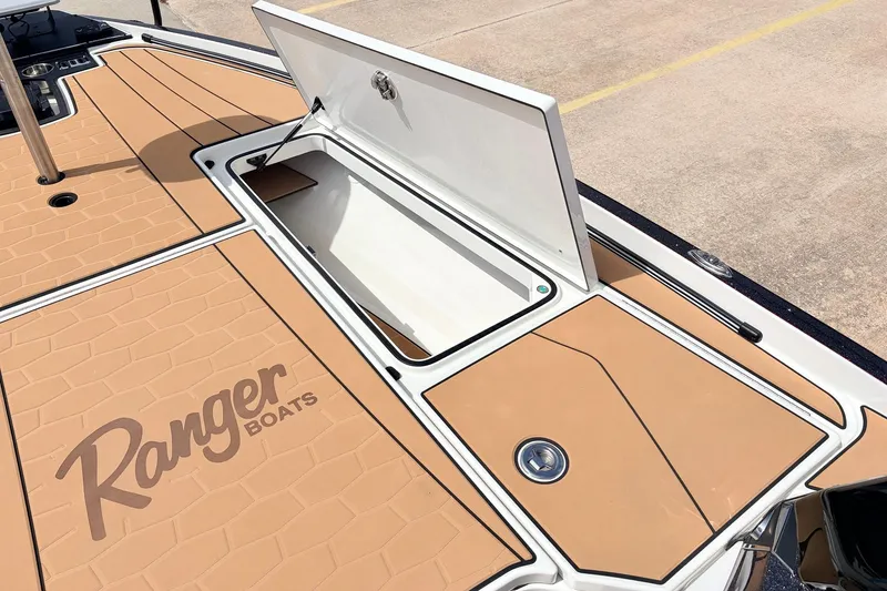 Slide: The Image of 2026 Ranger Z521R Ultra boat deck with open storage compartment, featuring tan non-slip surface. - 25