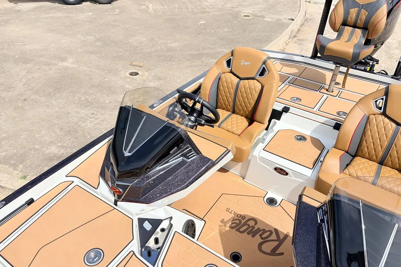 Slide: The Image of 2026 Ranger Z521R Ultra boat interior with tan and black seating, steering console, and deck. - 33