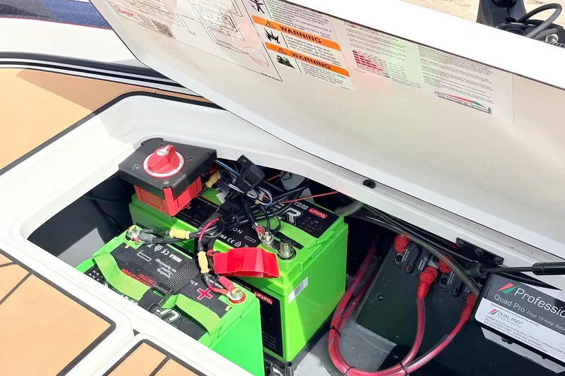 Slide: The Image of 2026 Ranger Z521R Ultra boat battery compartment with green batteries and wiring. - 59