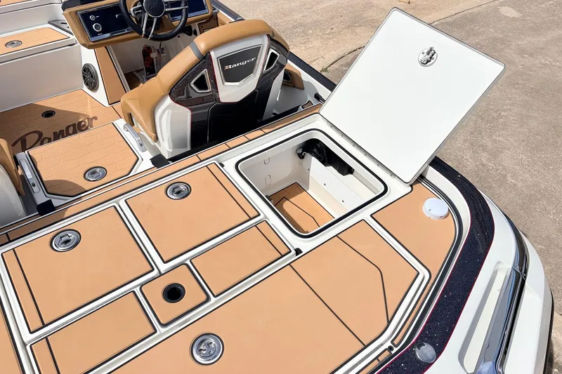 Slide: The Image of 2026 Ranger Z521R Ultra boat interior with open storage compartment and tan seating. - 56