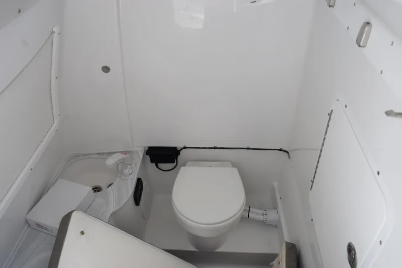 Slide: The Image of Interior of 2027 Sea Hunt Gamefish 28 boat, featuring a compact marine toilet. - 21