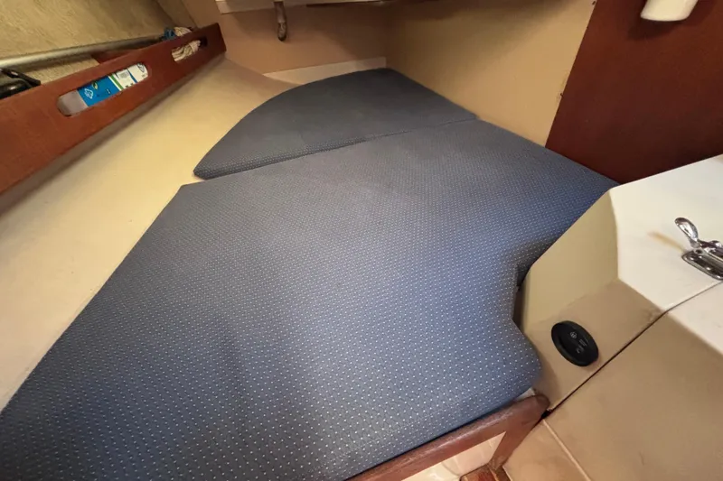 Slide: The Image of Interior cabin of a 1989 CAL 33 sailboat with blue cushioned seating. - 19