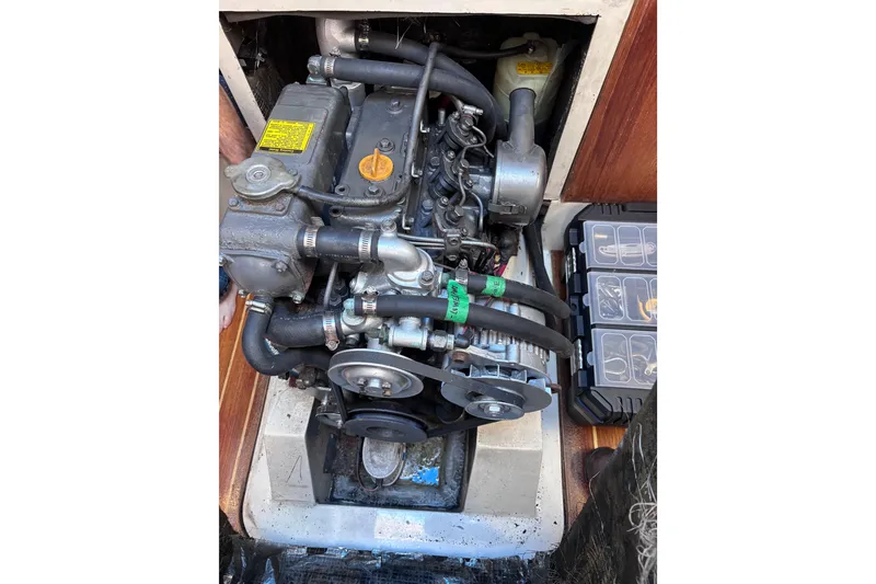 Slide: The Image of Engine compartment of a 1989 CAL 33 sailboat, featuring mechanical components and storage box. - 23