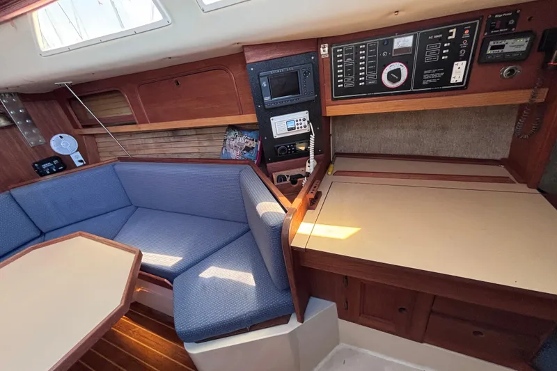 Slide: The Image of Interior of a 1989 CAL 33 sailboat featuring a cozy seating area and navigation panel. - 17