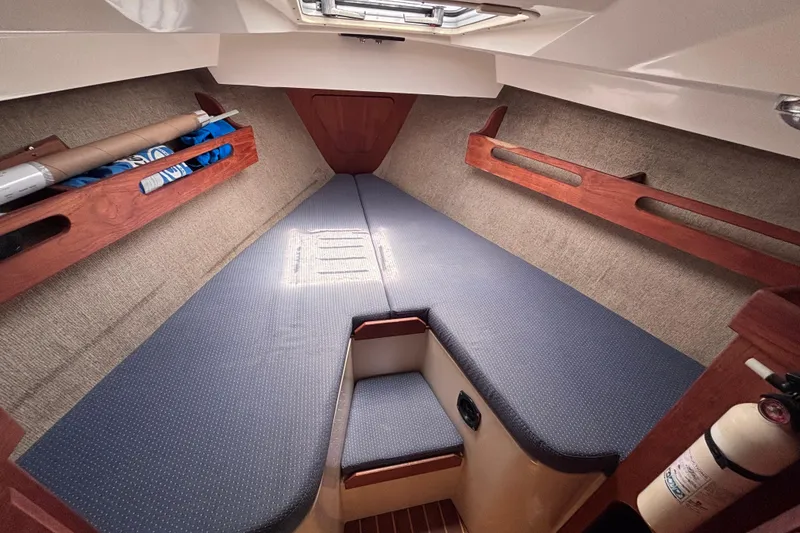 Slide: The Image of Cozy cabin interior of 1989 CAL 33 sailboat with blue cushions and wooden accents. - 20