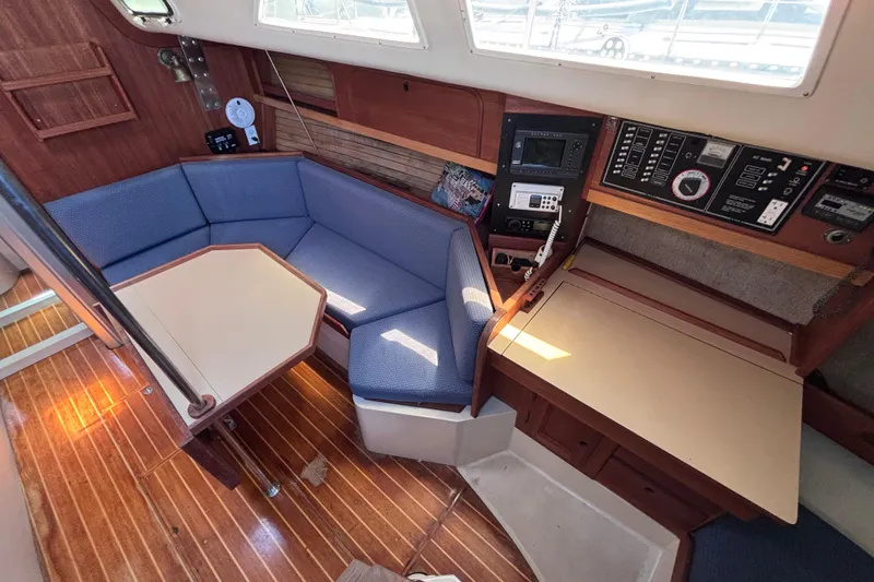 Slide: The Image of Cozy interior of 1989 CAL 33 sailboat with blue seating and navigation equipment. - 11