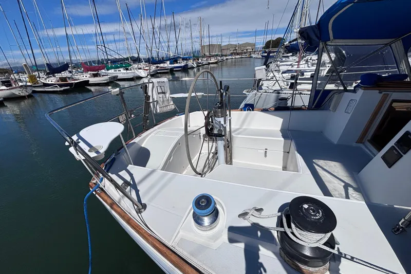 Slide: The Image of Sailboat docked in marina, CAL 33 model, 1989, with steering wheel and winches visible. - 8