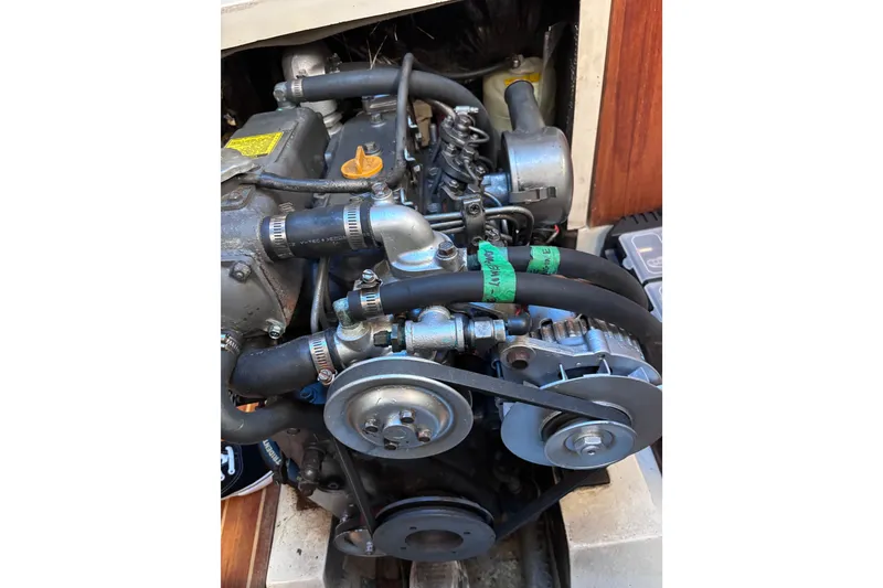 Slide: The Image of Engine of a 1989 CAL 33 sailboat, showcasing belts and hoses. - 27