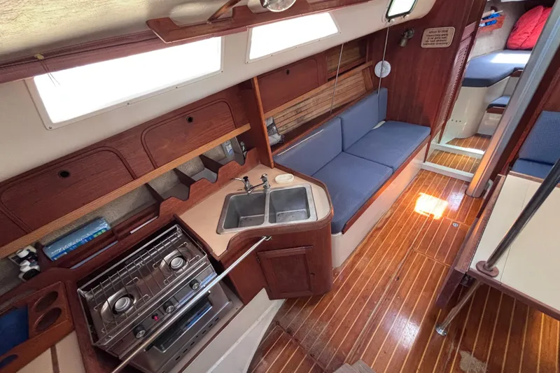Slide: The Image of Interior of a 1989 CAL 33 sailboat with kitchen and seating area. - 10