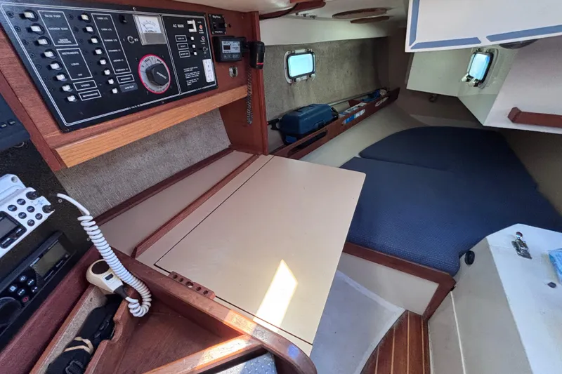 Slide: The Image of Interior of a 1989 CAL 33 sailboat featuring navigation panel and cozy sleeping area. - 18