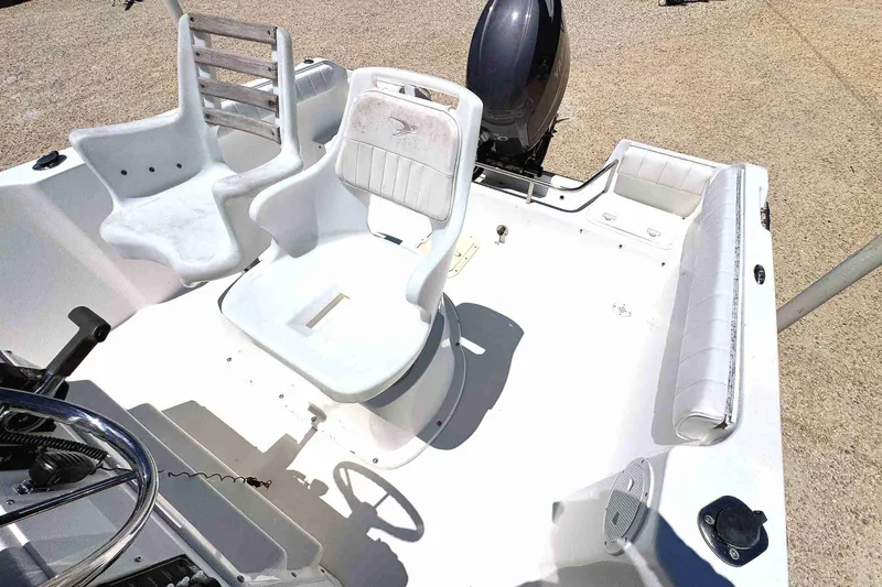 Slide: The Image of 2003 PRO SPORT 2200 Blue Water boat interior with white seating and steering wheel. - 9