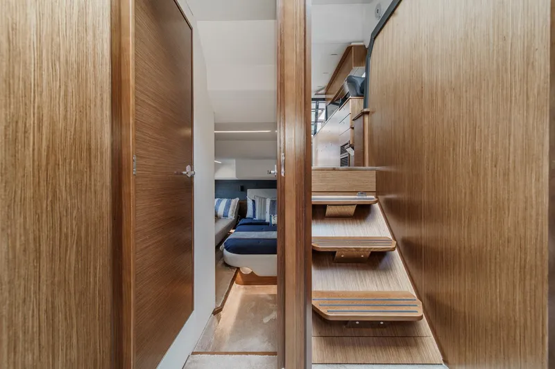 Slide: The Image of Interior of 2017 Bavaria R40 Fly yacht, featuring wooden stairs and cozy cabin space. - 49