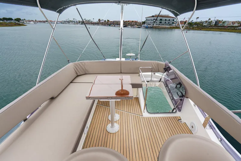 Slide: The Image of Flybridge view of 2017 Bavaria R40 Fly yacht with seating and table, overlooking calm waters. - 15