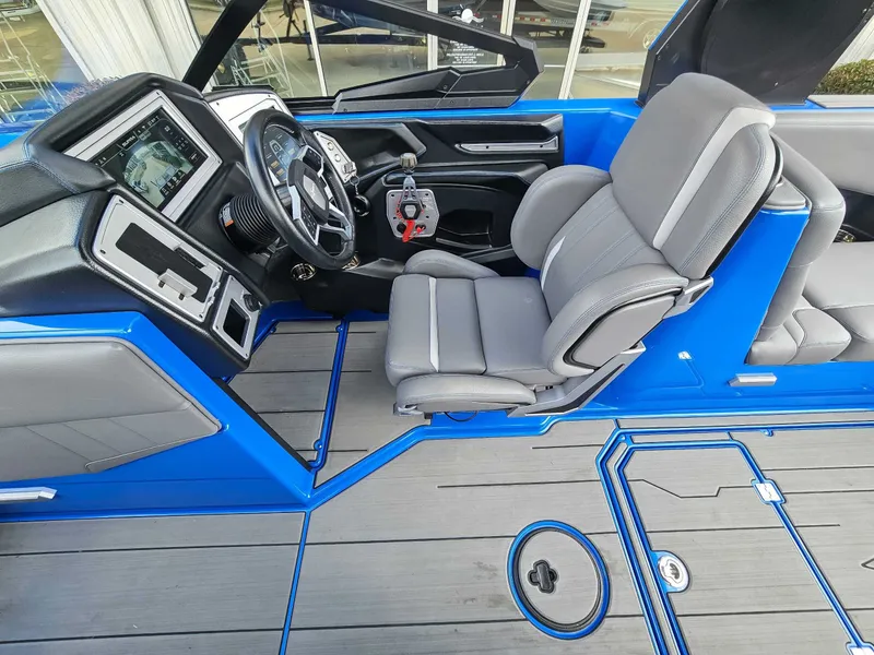 Slide: The Image of The image shows the cockpit of a blue 2021 Supra SE 450 boat with gray seats. - 13