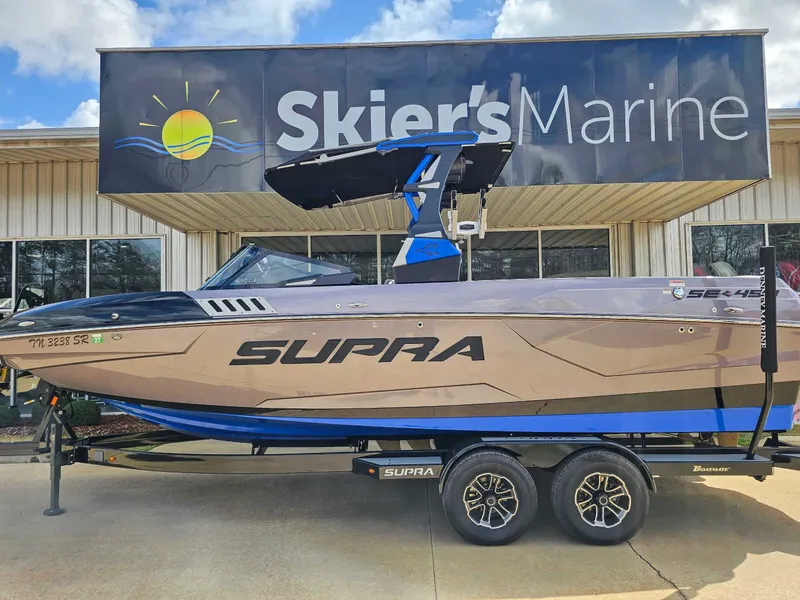 The Image of A 2021 Supra SE 450 boat on a trailer in front of a building labeled "Skier's Marine." - 1