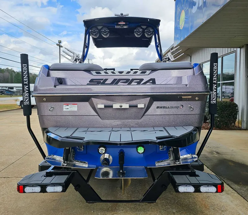 Slide: The Image of Rear view of a 2021 Supra SE 450 boat on a trailer, featuring distinctive lights and logo. - 8