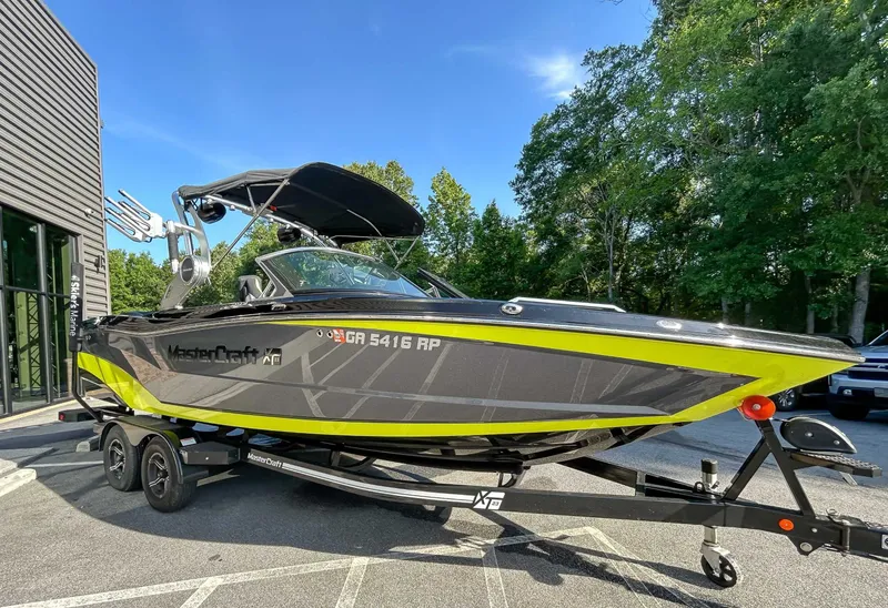 Slide: The Image of 2020 MasterCraft XT23 on a trailer, featuring a sleek design and black sunshade. - 3