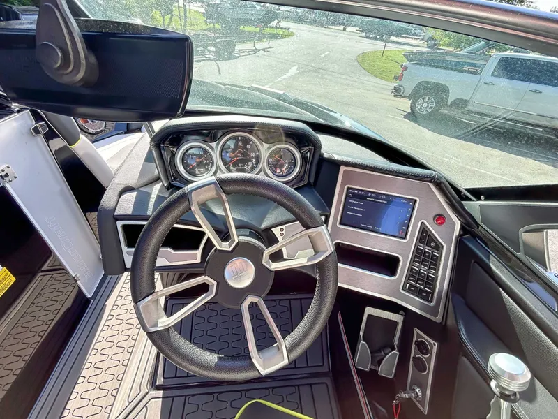 Slide: The Image of The cockpit of a 2020 MasterCraft XT23 with a modern steering wheel and digital displays. - 18