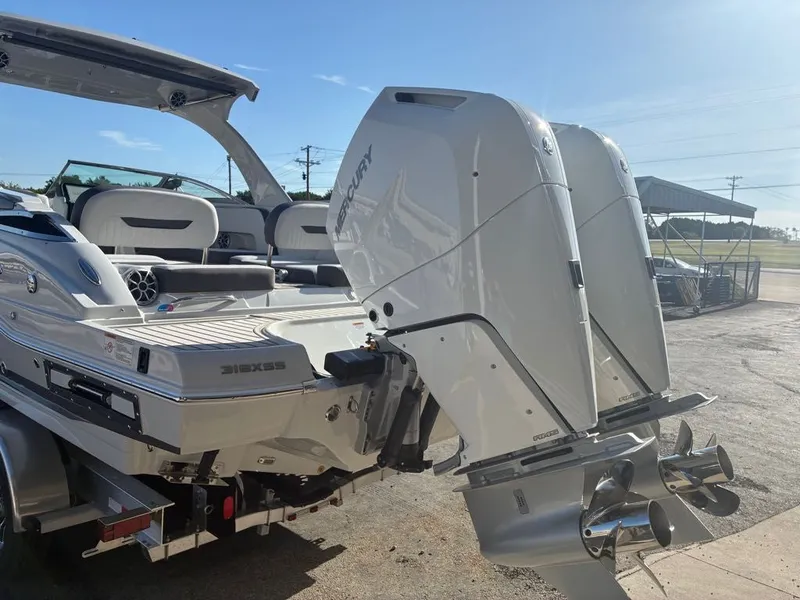Slide: The Image of 2027 Crownline 331SXSS with twin outboard engines, on a trailer on land. - 21