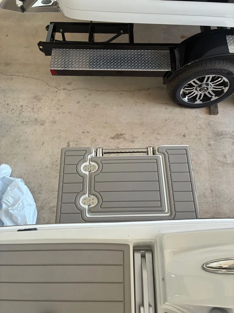 Slide: The Image of A boat with a gray deck and a step next to a trailer. - 15