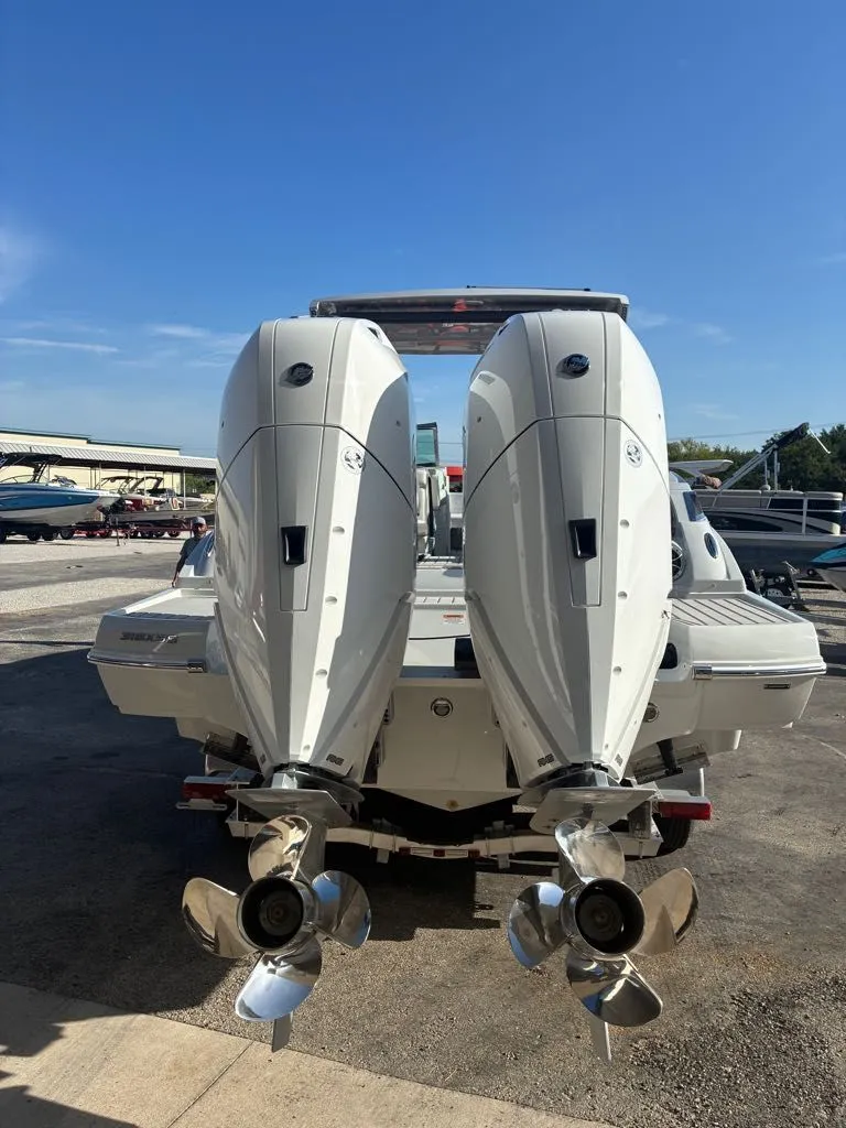 Slide: The Image of Two powerful outboard engines on a Crownline 331SXSS boat, positioned on a dry dock. - 13