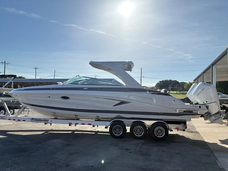 The Image of 2027 Crownline 331SXSS on a trailer, featuring a sleek design and twin outboard engines. - 1