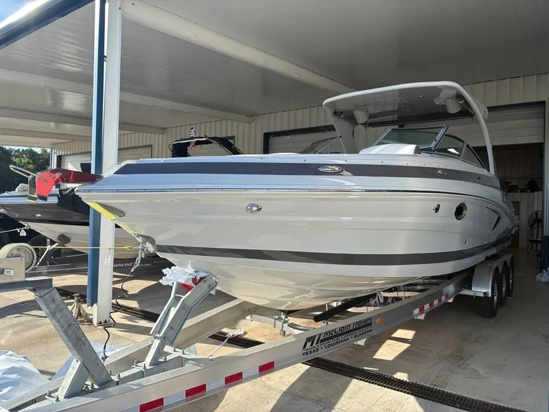 Slide: The Image of A modern 2027 Crownline 331SXSS sits on a trailer in a covered area. - 14