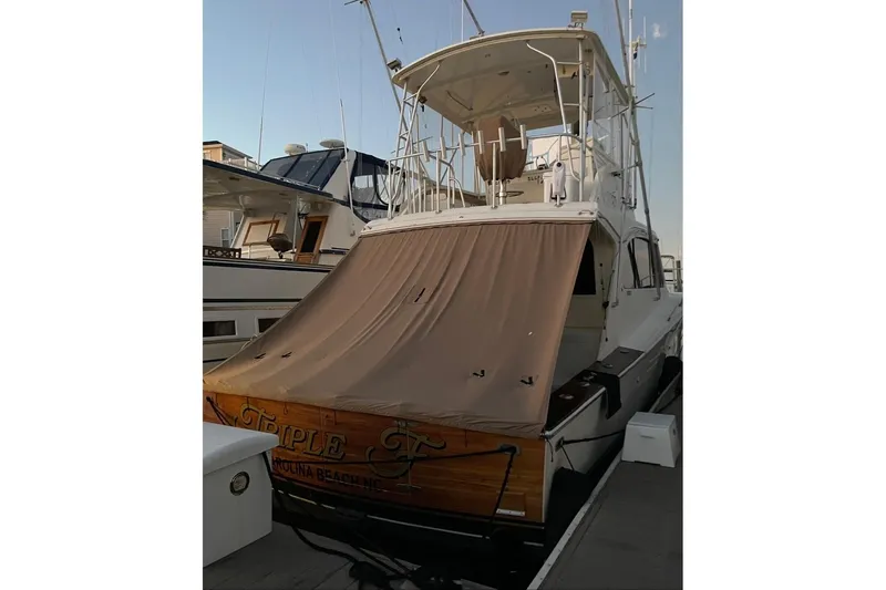 Slide: The Image of 1987 Post 43 Convertible yacht docked, featuring a covered stern and fishing tower. - 3