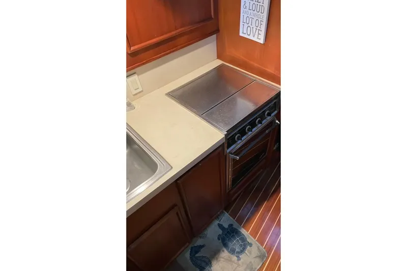 Slide: The Image of 1987 Post 43 Convertible kitchen with stove, sink, and wooden cabinetry. - 17