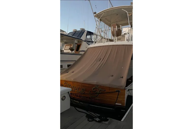 Slide: The Image of 1987 Post 43 Convertible yacht docked, covered with a brown tarp. - 22