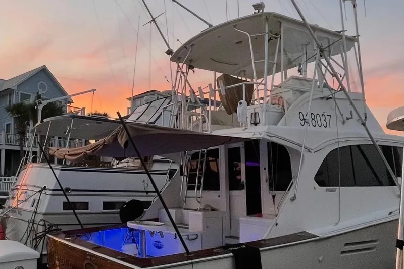 Slide: The Image of 1987 Post 43 Convertible yacht docked at sunset, featuring a spacious deck and fishing equipment. - 5
