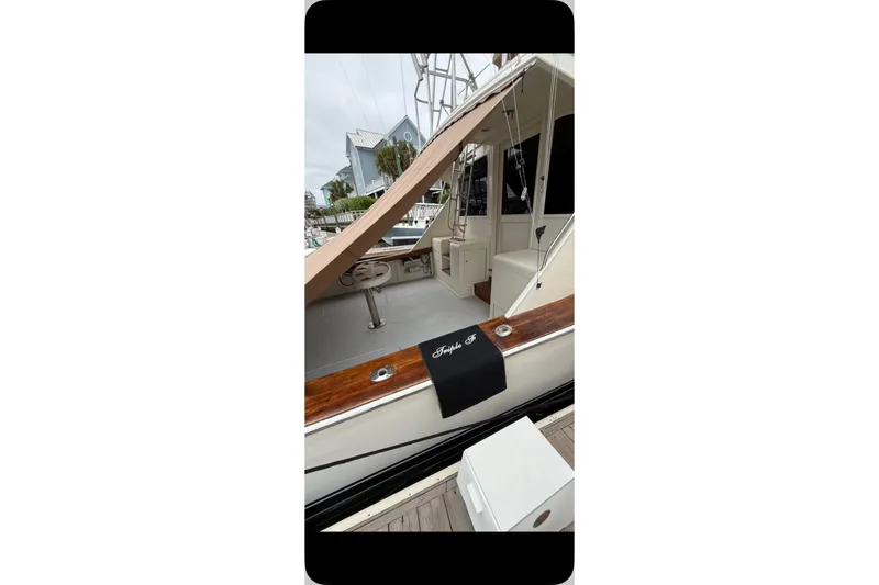 Slide: The Image of 1987 Post 43 Convertible yacht docked, featuring a sleek design and wooden accents. - 23