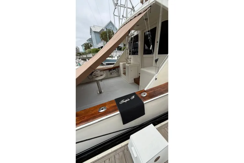 Slide: The Image of 1987 Post 43 Convertible yacht docked, featuring a spacious deck and elegant wood accents. - 25