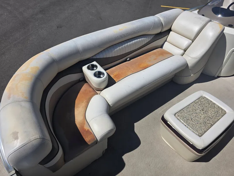 Slide: The Image of The image shows a worn seating area on a boat with cup holders and a small table. - 12
