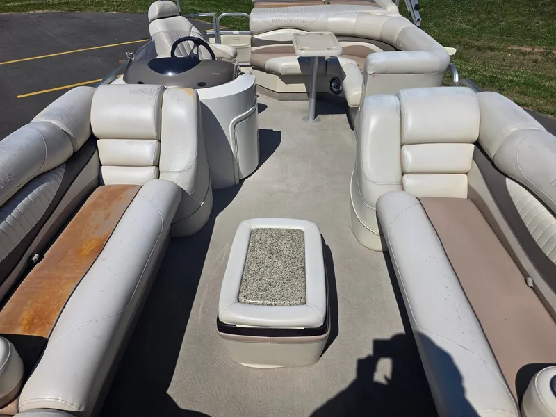 Slide: The Image of Interior of a Bennington 2275RL SPS TRI pontoon boat with white and beige seating and a helm station. - 13