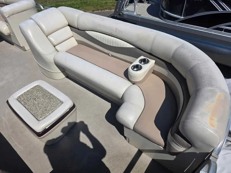 Slide: The Image of A sleek, cream-colored seating sofa with built-in cup holders on a boat. - 11