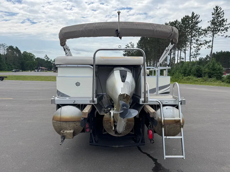 Slide: The Image of A 2008 Bennington 2275RL SPS TRI pontoon boat is parked. It features an outboard motor and ladder. - 10